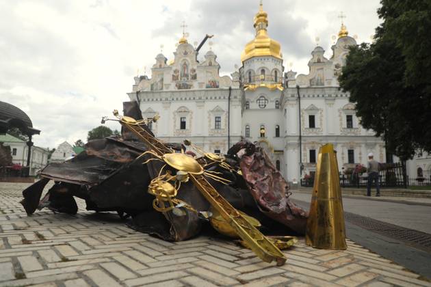 An old gilded cross, deformed by the blast wave, and pieces of burnt metal plating lie on the ground outside the Dormition Cathedral at the Kyiv Pechersk Lavra, which was hit by a Russian drone during a massive attack on the Ukrainian capital on Monday night, June 15, Kyiv, Ukraine, June 16, 2026. The strike triggered a large-scale fire that covered about 800 sq m and damaged 80% of the roof structure. (Photo by Yuliia Ovsiannikova Ukrinform) Briefing on aftermath of Russian attack on cultural heritage sites of Kyiv  Copyright: xYuliiaxOvsiannikovax