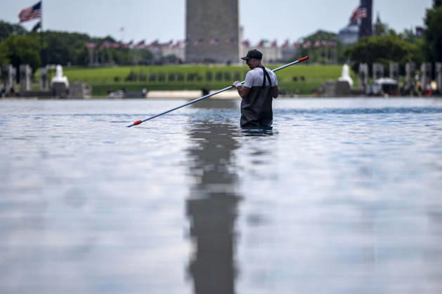 A U.S. National Park Service employee uses a vacuum pump to clean algae off the bottom of the newly repainted Lincoln Memorial Reflecting Pool on the National Mall in Washington, DC on Wednesday, June 17, 2026. The Trump Administration spent $16 million to paint the bottom of the pool American flag blue and as part of an effort to repair Washington landmarks in for preparation the country s 250th birthday this summer.  WAP20260617302 BONNIExCASH