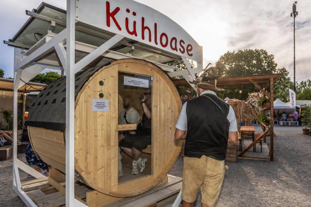 Tollwood Sommerfestival 2026, Kühloase zur Abkühlung bei hochsommerlichen Temperaturen über 30 Grad, umfunktioniertes Saunafass, München, 19. Juni 2026 Deutschland, München, 19. Juni 2026, Eröffnung des Tollwood Sommerfestivals 2026, Kühloase zur Abkühlung bei hochsommerlichen Temperaturen über 30 Grad, umfunktioniertes Saunafass für 4 Personen, dessen Klimaanlage im Innern mit Solarpanels betrieben wird, Teil des neuen Tollwood-Hitzekonzepts, Besucher schwitzen bei Rekordtemperaturen über 30 Grad, Hochsommer, das Tollwood ist multikulturelles Festival, das im Sommer im Olympiapark stattfindet, dieses Jahr vom 19. Juni bis 19. Juli, d2026 unter dem Motto: Mit Gefühl statt nur dabei die Rückeroberung der Empathie, Festivalg