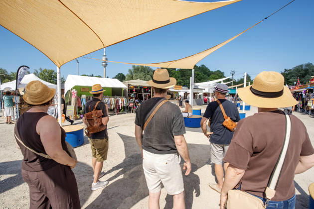 Tollwood Sommerfestival 2026, Besuchergruppe unter Sonnensegeln, Hitzeschutz bei hochsommerlichen Temperaturen über 30 Grad, München, 19. Juni 2026 Deutschland, München, 19. Juni 2026, Eröffnung des Tollwood Sommerfestivals 2026, Besuchergruppe mit Strohhüten unter Sonnensegeln, Hitzeschutz bei hochsommerlichen Temperaturen über 30 Grad, Teil des neuen Tollwood-Hitzekonzepts, Besucher schwitzen bei Rekordtemperaturen über 30 Grad, Hochsommer, das Tollwood ist multikulturelles Festival, das im Sommer im Olympiapark stattfindet, dieses Jahr vom 19. Juni bis 19. Juli, 2026 unter dem Motto: Mit Gefühl statt nur dabei die Rückeroberung der Empathie, Festivalgelände, Sommer, Kultur, Veranstaltung, Bayern