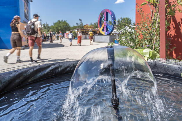 Eröffnung des Tollwood Sommerfestivals 2026, Besucher können sich bei hochsommerlichen Temperaturen über 30 Grad an diesen Brunnen abkühlen, München, 19. Juni 2026 Deutschland, München, 19. Juni 2026, Eröffnung des Tollwood Sommerfestivals 2026, einer von mehreren kleinen Kühlbrunnen, an denen sich die Besucher abkühlen können, Teil des neuen Tollwood-Hitzekonzepts, Besucher schwitzen bei Rekordtemperaturen über 30 Grad, Hochsommer, das Tollwood ist ein multikulturelles Festival, das im Sommer im Olympiapark stattfindet, dieses Jahr vom 19. Juni bis 19. Juli, 2026 unter dem Motto: Mit Gefühl statt nur dabei die Rückeroberung der Empathie, Festivalgelände, Sommer, Kultur, Veranstaltung, Klima, Bayern