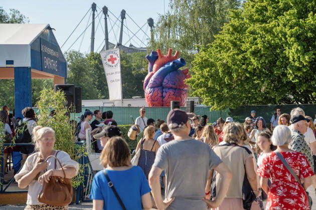 Eröffnung des Tollwood Sommerfestivals 2026, Besucher und Besucherinnen strömen auf das Tollwood-Gelände, ein übergroßes Herz ist das Symbol des Festivals, , München, 19. Juni 2026 Deutschland, München, 19. Juni 2026, Eröffnung des Tollwood Sommerfestivals 2026, Besucher und Besucherinnen strömen auf das Festivalgelände, ein übergroßes Herz ist das Symbol des Festivals, das Tollwood ist ein multikulturelles Festival, das im Sommer im Olympiapark stattfindet, dieses Jahr vom 19. Juni bis 19. Juli, 2026 unter dem Motto: Mit Gefühl statt nur dabei die Rückeroberung der Empathie, Sommerhitze mit Temperaturen über 30 Grad, Festivalgelände, Zelte und Stände, Sommer, Kultur, Veranstaltung, Bayern