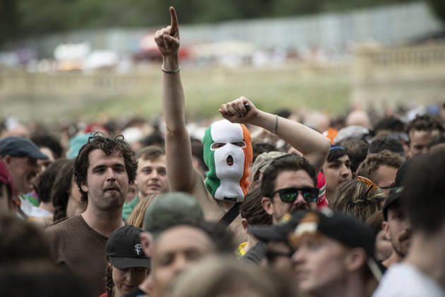 Kneecap performing live at Crystal Palace Park, London 27 June 2026 Kneecap performing live at Crystal Palace Park, London 27 June 2026 Fans in the crowd Kneecap are an Irish hip-hop trio. They rap in a mixture of English and Irish. Their first single C.E.A.R.T.A. (cearta is Irish for rights ) was released in ˜17, followed by their mixtape, 3CAG, in ˜18. Their first studio album, Fine Art, was released in ˜24 Their second studio album, Fenian, was released in ˜26. The group has been at the centre of public debates about free speech and the expression of political opinions within Ireland and the UK. Their themes focus on working class, youth culture, Irish republicanism and Irish language rights. In concert, they have made stateme Copyright: xDafyddxOwenx xDafyddxOwenx-xB5377x xAvalonx 1112995135