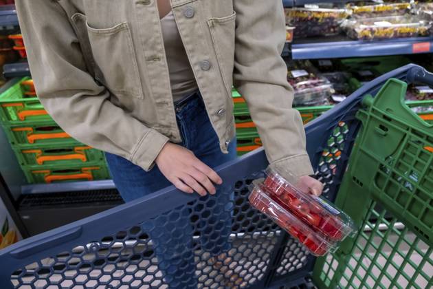 Person, die Lebensmittel einkauft, einen Plastikbehälter mit reifen roten Erdbeeren in einen dunkelblauen Einkaufswagen legt und sich durch die Lebensmittelabteilung eines Supermarkts bewegt Person shopping for groceries, adding a plastic container of ripe red strawberries to a dark blue shopping cart, moving through the produce section of a supermarket Copyright: imageBROKER UnaixHuizi ibxuhu18171691.jpg ,model released, Symbolfoto ,property released
