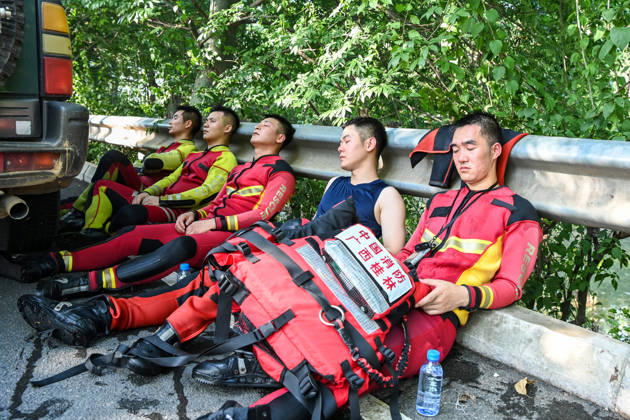 (260711) -- NANNING, July 11, 2026 -- Rescuers take turns to rest by a street in Guigang, south China s Guangxi Zhuang Autonomous Region, July 10, 2026. Triggered by Typhoon Maysak, the tenth typhoon of the year, heavy downpours battered multiple areas in south China s Guangxi Zhuang Autonomous Region, resulting in a series of disasters. Various response forces have pooled their efforts, carrying out operations including rescue missions in remote mountainous areas, restoration of transport and power infrastructure, and silt clearing operations. ) CHINA-GUANGXI-TYPHOON-FLOOD-RESCUE (CN) CaoxYiming