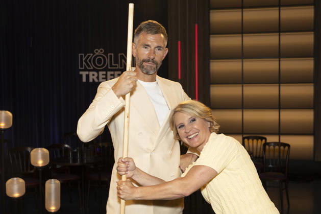 Moderator Micky BEISENHERZ (li.) und Moderatorin Susan LINK (re.) halten sich an einer Shaolin Bo Stange fest, Portrait, Portraet, in der TV Sendung ,,Koelner Treff,, im WDR Fernsehen, Aufzeichnung am 10.07.2026, Ausstrahlung am 07.08.2026.