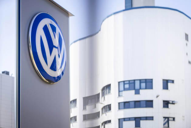 Symbolbild Volkswagen Osnabrück. VW Logo am Tor 2 durch den Zaun fotografiert mit weißem Werksgebäude im Hintergrund. VW-Werk in Osnabrück 11.07.2026 Symbolbild VW Osnabrück