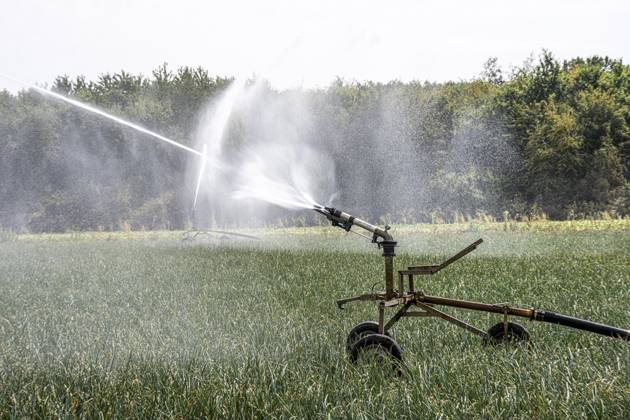 Künstliche Bewässerung eines Feldes mit einer Beregnungsanlage, lange Trockenheit im Sommer macht dies notwendig um die Ernte zu sichern, bei Niederkrüchten NRW, Deutschland Künstliche Bewässerung