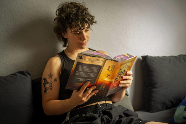 07.08.2026, Buchreihe von Rebecca Yarros, IRON FLAME, ein Teenager in Bad Wörishofen in Bayern sitzt auf ihrem Sofa und liest ihr Spannendes Buch. (Modelreleased) 07.08.2026, Jugendbücher 07.08.2026, Jugendbücher