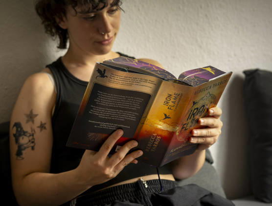 07.08.2026, Buchreihe von Rebecca Yarros, IRON FLAME, ein Teenager in Bad Wörishofen in Bayern sitzt auf ihrem Sofa und liest ihr Spannendes Buch. (Modelreleased) 07.08.2026, Jugendbücher 07.08.2026, Jugendbücher