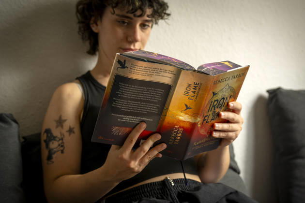 07.08.2026, Buchreihe von Rebecca Yarros, IRON FLAME, ein Teenager in Bad Wörishofen in Bayern sitzt auf ihrem Sofa und liest ihr Spannendes Buch. (Modelreleased) 07.08.2026, Jugendbücher 07.08.2026, Jugendbücher