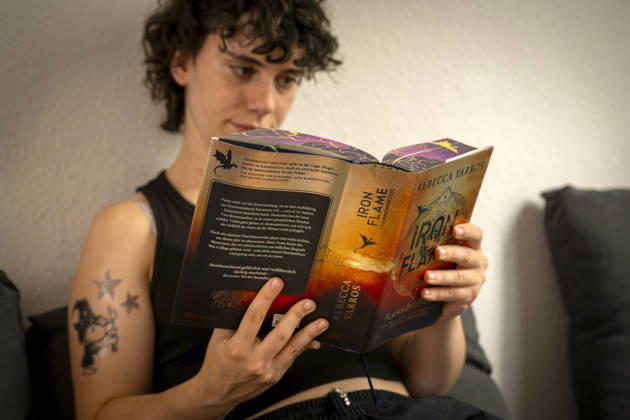 07.08.2026, Buchreihe von Rebecca Yarros, IRON FLAME, ein Teenager in Bad Wörishofen in Bayern sitzt auf ihrem Sofa und liest ihr Spannendes Buch. (Modelreleased) 07.08.2026, Jugendbücher 07.08.2026, Jugendbücher