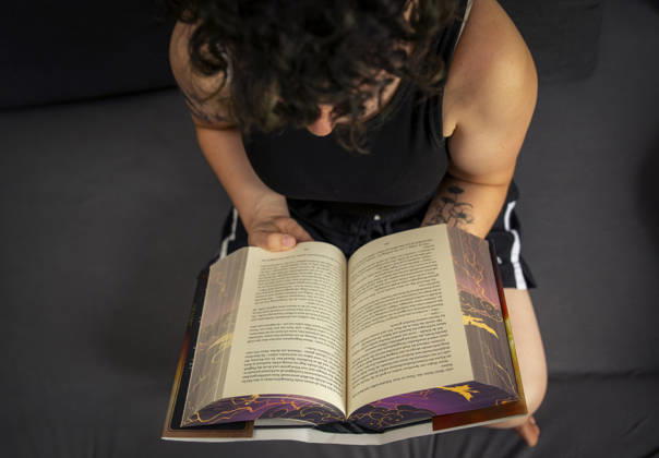 07.08.2026, Buchreihe von Rebecca Yarros, IRON FLAME, ein Teenager in Bad Wörishofen in Bayern sitzt auf ihrem Sofa und liest ihr Spannendes Buch. (Modelreleased) 07.08.2026, Jugendbücher 07.08.2026, Jugendbücher
