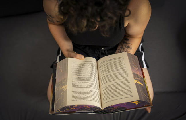 07.08.2026, Buchreihe von Rebecca Yarros, IRON FLAME, ein Teenager in Bad Wörishofen in Bayern sitzt auf ihrem Sofa und liest ihr Spannendes Buch. (Modelreleased) 07.08.2026, Jugendbücher 07.08.2026, Jugendbücher