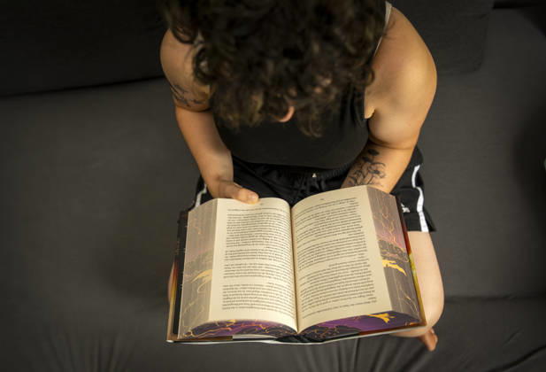 07.08.2026, Buchreihe von Rebecca Yarros, IRON FLAME, ein Teenager in Bad Wörishofen in Bayern sitzt auf ihrem Sofa und liest ihr Spannendes Buch. (Modelreleased) 07.08.2026, Jugendbücher 07.08.2026, Jugendbücher