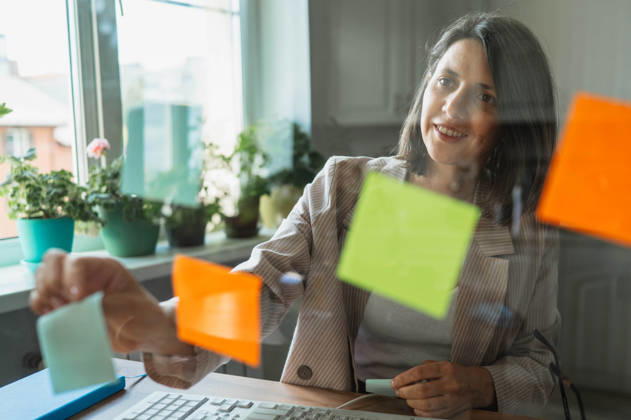 Smiling businesswoman planning strategy with notes at home office model released, Symbolfoto property released, ANAF06471