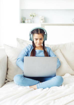 Ein Schulmädchen mit Kopfhörern sitzt auf dem Sofa und arbeitet an einem Laptop Ein Schulmädchen mit Kopfhörern sitzt auf dem Sofa und arbeitet an einem Laptop (License=RF) ,model released, Symbolfoto Copyright: xZoonar.com RaisaxKanarevax 25366768 ,model released, Symbolfoto ,property released