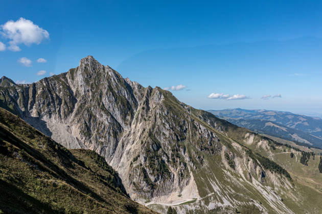 Zackiger Alpengipfel und grasbewachsener Bergrücken im Berner Oberland - dramatische Berglandschaft der Schweizer Alpen