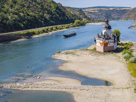Der Pegel des Rhein ist auf einem Tiefststand. Die Rheinschifffahrt ist durch das Niedrigwasser extrem beeinträchtigt. Es fahren nur noch wenige Schiffe, und die sind mit reduzierter Fracht unterwegs. Burg Pfalzgrafenstein in Kaub am Mittelrhein. Die Sehenswürdigkeit ist eine auf einer Felseninsel im Rhein errichtete frühere Zollburg. 12.08.2026, Kaub, Rheinland-Pfalz, Deutschland