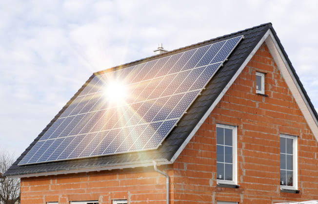 Eine PV-Solar- Anlage auf einem Hausdach Eine Photovoltaikanlage auf dem Hausdach von einem Neubau erzeugt grünen Strom - FOTOMONTAGE - NUR FÜR REDAKTIONELLE VERWENDUNG -