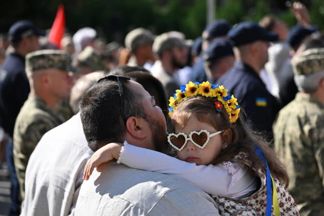 National Flag Day of Ukraine in Lviv LVIV, UKRAINE - AUGUST 23: A child wearing a floral wreath in the colors of the Ukrainian flag is carried by a man during a National Flag Day ceremony in Lviv, Ukraine, on August 23, 2026. Due to the ongoing Russian-Ukrainian War, celebrations were limited to a ceremonial raising of the Ukrainian flag on the city s highest flagpole with the participation of soldiers from various branches of the armed forces. Participants also observed a minute of silence for those killed, sang the Ukrainian national anthem, and listened to patriotic and folk songs performed by a military orchestra. Michael Sorrow Anadolu Lviv Ukraine. Editorial use only. Please get in touch for any other usage.  Copyright: x2026xAnadoluxMichaelxSorrowx