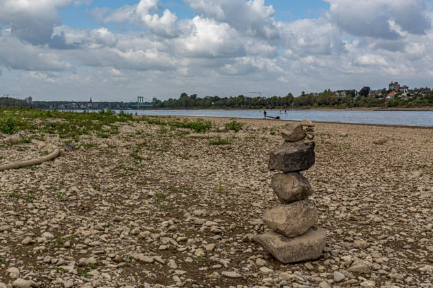 Blick auf das ausgetrocknete Flussbett des Rheins und Porz auf der rechten Rheinseite, gesehen vom Weißer Rheinbogen bei Köln-Sürth. Von den Tiefstständen haben sich die Pegelständde am Rhein inzwischen wieder leicht entfernt. Im Hintergrund ist die Rodenkirchener Brücke zu sehen. Niedrigwasser Rhein