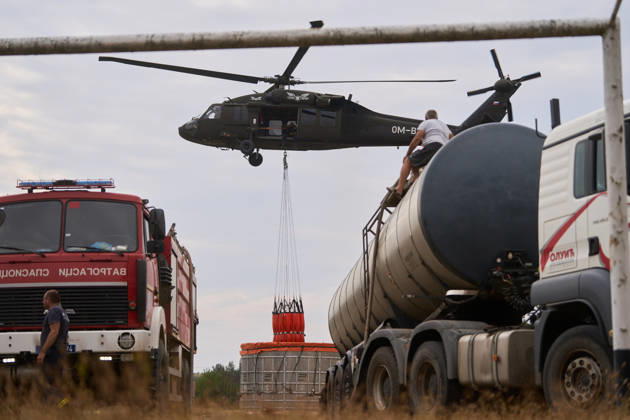 News Bilder des Tages August 25, 2026, Susara, Vojvodina, Serbia: 2026825, Susara, Serbia - Two Sikorsky UH-60 Black Hawk helicopters are deployed to the village of Susara to help battle the severe wildfires devastating the Deliblato Sands (Deliblatska Pescara) Special Nature Reserve, refilling their buckets from a large portable water tank placed on a local football pitch. Susara Serbia - ZUMAd223 20260825_zip_d223_004 Copyright: xMarkoxDimicx