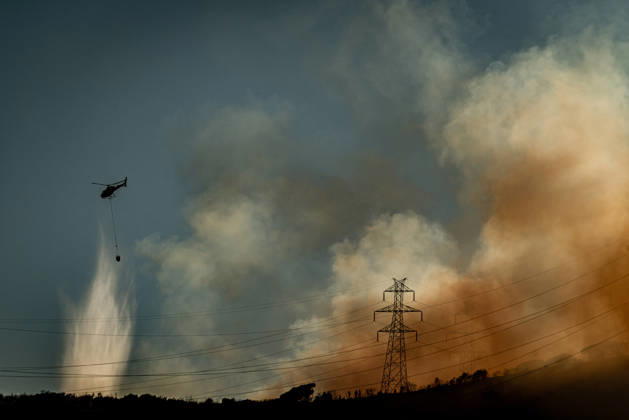 August 25, 2026, Barcelona, Spain: A helicopter drops water on a wildfire burning in the Collserola mountain range in Barcelona as thick smoke rises over the hills. The fire has affected the city s Nou Barris district, prompting authorities to evacuate and shelter residents in the Torre Baro and Ciutat Meridiana neighborhoods. Barcelona Spain - ZUMAb137 20260825_fap_b137_017 Copyright: xJordixBoixareux