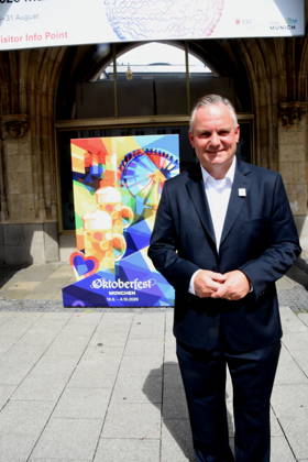 Dr Christian Scharpf Wirtschaftsreferent vor Oktoberfest 2026 Plakat Muenchen 26.08.2026 Marienplatz vor Symbol Olympia Waldi Oberbürgermeister Dominik Krause Wirtschaftsreferent Dr. Christian Scharpf geben gemeinsam mit Wolfram Hatz, Präsident der Vereinigung der Bayerischen Wirtschaft, und dem IHK-Regionalausschuss-den David Boppert als Vertretern des Bündnisses PRO Olympia den schuss für den Countdown zur Entscheidung des Deutschen Sportbunds, welcher Kandidat für Deutschland ins internationale um die Austragung der Olympischen und Paralympischen Sommerspiele ab 2036 geht. Foto Muenchen