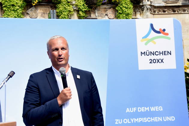 HK-Regionalausschuss-den David Boppert als Vertretern des Bündnisses PRO Olympia Muenchen 26.08.2026 Marienplatz vor Symbol Olympia Waldi Oberbürgermeister Dominik Krause Wirtschaftsreferent Dr. Christian Scharpf geben gemeinsam mit Wolfram Hatz, Präsident der Vereinigung der Bayerischen Wirtschaft, und dem IHK-Regionalausschuss-den David Boppert als Vertretern des Bündnisses PRO Olympia den schuss für den Countdown zur Entscheidung des Deutschen Sportbunds, welcher Kandidat für Deutschland ins internationale um die Austragung der Olympischen und Paralympischen Sommerspiele ab 2036 geht. Foto Muenchen