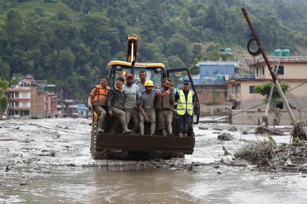 August 26, 2026, Nuwakot, Nepal: Security personnel rescue people in a dozer from buildings and infrastructure that were damaged along the swollen Trishuli River following a massive flash flood triggered by an avalanche of ice and rock in the upper Lhende River on the Tibetan side, in Nuwakot district, Nepal, on Wednesday, August 26, 2026. The sudden flood swept through communities along the Bhote Koshi and Trishuli river systems, destroying homes, roads and bridges and leaving widespread devastation downstream. Nuwakot Nepal - ZUMAg200 20260826_zap_g200_015 Copyright: xSkandaxGautamx