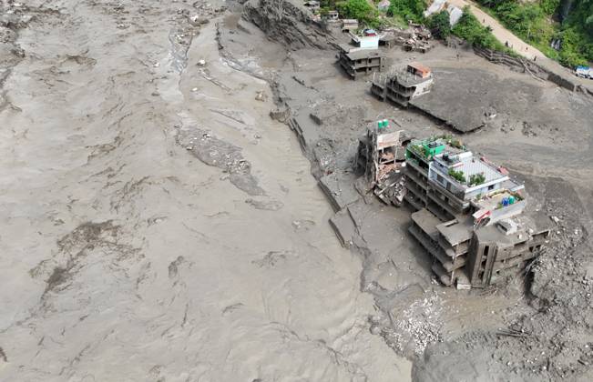 August 26, 2026, Nuwakot, Nepal: An aerial view shows buildings and infrastructure damaged along the swollen Trishuli River following a massive flash flood triggered by an avalanche of ice and rock in the upper Lhende River on the Tibetan side, in Nuwakot district, Nepal, on Wednesday, August 26, 2026. The sudden flood swept through communities along the Bhote Koshi and Trishuli river systems, destroying homes, roads and bridges and leaving widespread devastation downstream. Nuwakot Nepal - ZUMAg200 20260826_zap_g200_017 Copyright: xSkandaxGautamx
