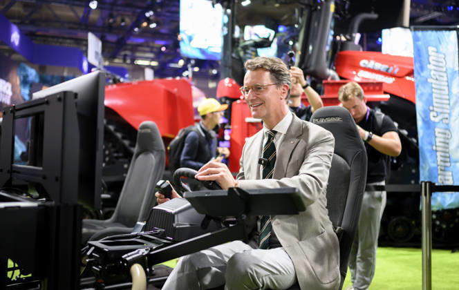 Hendrik Wüst (CDU, Ministerpräsident des Landes Nordrhein-Westfalen) sitzt auf einem Gamingstuhl und spielt einen Landwirtschafts simulator, Presserundgang. Politische Eröffnung der gamescom, am 26.08.2026 gamescom vom 26.08. - 30.08.2026 in Köln Deutschland. Messe