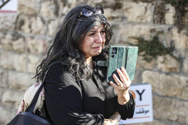 Palestinians Mourn Artist Sliman Mansour A woman wipes tears while holding a mobile phone during the funeral of renowned Palestinian artist Sliman Mansour in Birzeit, north of Ramallah, in the occupied West Bank, on August 26, 2026. Mansour, one of the most prominent figures in contemporary Palestinian visual art, died on August 24 at the age of 79 and was known for works depicting Palestinian landscapes, heritage and life under Israeli occupation, including his 1973 painting Camel of Hardships. Ramallah West Bank Palestinian Territories Copyright: xMohammadxNazzalx