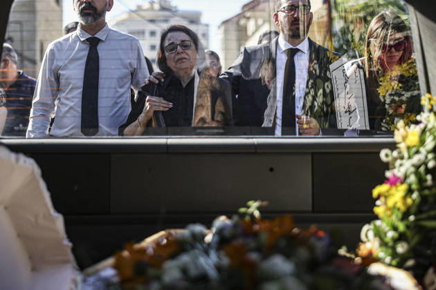 Palestinians Mourn Artist Sliman Mansour Mourners stand beside the flower-covered coffin of renowned Palestinian artist Sliman Mansour during his funeral in Birzeit, north of Ramallah, in the occupied West Bank, on August 26, 2026. Mansour, one of the most prominent figures in contemporary Palestinian visual art, died on August 24 at the age of 79 and was known for works depicting Palestinian landscapes, heritage and life under Israeli occupation, including his 1973 painting Camel of Hardships. Ramallah West Bank Palestinian Territories Copyright: xMohammadxNazzalx