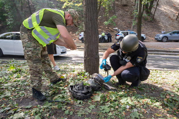 Forensic experts take pictures of fragments of a Russian drone found on Parkova Doroha Street in the Pecherskyi district after a Russian attack, Kyiv, Ukraine, August 27, 2026. Since the night of August 27, the Russian army has been striking the Ukrainian capital with ballistic missiles and drones. Overnight and daytime attacks and falling debris caused destruction across several districts of Kyiv, damaging residential buildings, cars, gymnasium premises and a medical facility. (Photo by Danylo Antoniuk Ukrinform) Forensic experts examine wreckage of Russian drone in Kyiv  Copyright: xDanyloxAntoniukx