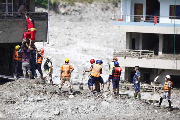 August 28, 2026, Nuwakot, Nepal: A woman climbs on top of her home to retrieve goods following flash floods at Devighat in Bidur Municipality. The floods, triggered by a glacial collapse, has killed at least 270 people and left 826 others out of contact, according to Nepalese authorities, with search and rescue operations continuing. Nuwakot Nepal  - ZUMAs197 20260828_aaa_s197_001 Copyright: xSkandaxGautamx