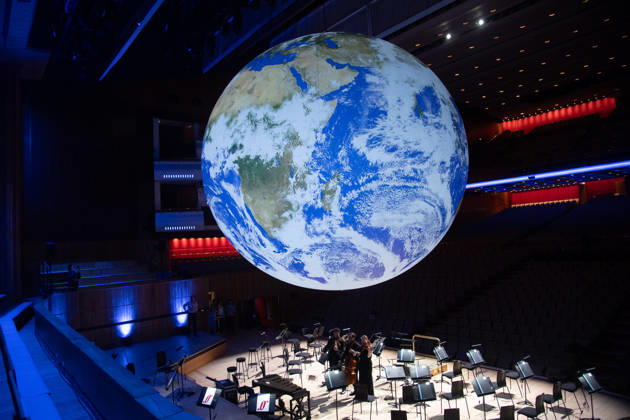 Luke Jerram s Earth Installation GAIA Suspended over Royal Festival Hall Stage at Royal Festival Hall, London, UK - Thursday 27 August 2026 A General view of GAIA by Luke Jerram with members of the BBC Concert Orchestra at Royal Festival Hall, London, England, UK on Thursday 27 August, 2026. The Installation runs from Friday 28th August - 30th August 2026 and Orchestral performances from the BBC Concert Orchestra will take place on Friday 28th and Saturday 29th August 2026., Credit:Justin Ng Avalon UK, England, London, Royal Festival Hall Copyright: xJustinxNgx xAvalonx 1128810196