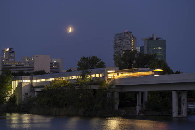 Moon during partial eclipse seen from Austria™s capital Vienna, in frame is the subway station Alte Donau. Vienna Vienna Austria