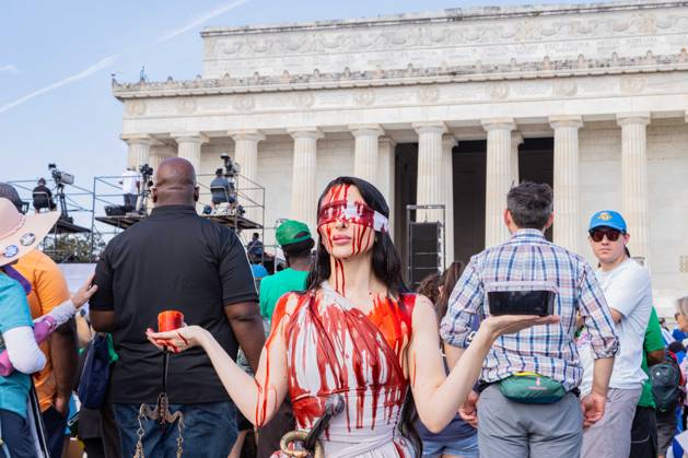 August 28, 2026, Washington, District Of Columbia, USA: A demonstrator does performative art at the march on Washington. The demonstrator requested that people pour symbolic blood on her head in order to protest political violence. Washington USA - ZUMAw218 20260828_znp_w218_001 Copyright: xRyanxWiramidjajax