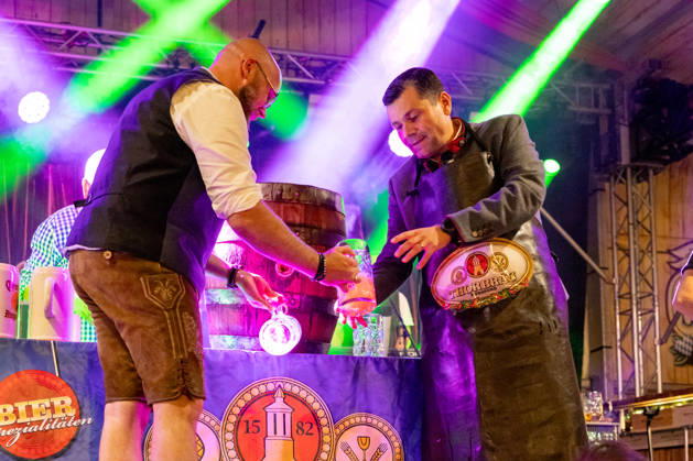 Eröffnung Plärrer in Augsburg. Nach dem traditionellen Fassanstich wird beim Augsburger Herbstplärrer Freibier ausgegeben. Besucher reichen ihre Maßkrüge zur Bühne und lassen sich Bier direkt aus dem Fass einschenken