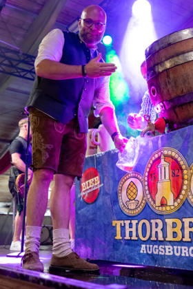 Eröffnung Plärrer in Augsburg. Nach dem traditionellen Fassanstich wird beim Augsburger Herbstplärrer Freibier ausgegeben. Besucher reichen ihre Maßkrüge zur Bühne und lassen sich Bier direkt aus dem Fass einschenken