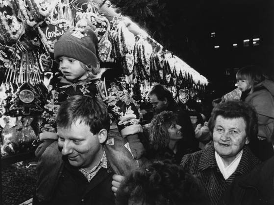 Nürnberger Christkindlesmarkt Ein Mann trägt ein Kind auf den Schultern auf dem Nürnberger Christkindlesmarkt, im Hintergrund ein Stand mit Lebkuchenherzen, 27.11.1992 Nürnberg Bayern Deutschland