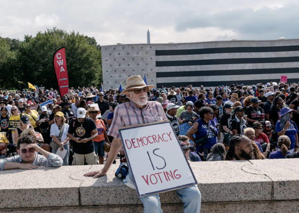 August 28, 2026, Washington, Distict Of Columbia, U.S.A: A demonstrator holds a sign that reads, â€oeDemocracy Is Voting,†while attending the â€oeMarch on Washington: Defend the Vote†rally at the Lincoln Memorial in Washington, DC, on August 28, 2026. The rally, organized by the National Action Network, marks the 63rd anniversary of the 1963 March on Washington, where Rev. Martin Luther King Jr. delivered his historic â€oeI Have a Dream†speech. Thousands of demonstrators are expected to gather to call attention to voting rights ahead of Novemberâ€⠢s midterm elections. Washington U.S.A - ZUMAr125 20260828_fap_r125_004 Copyright: xProbalxRashidx