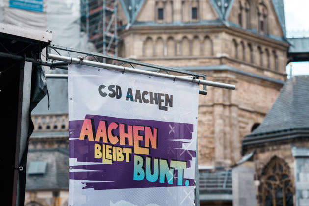 Deutschland, Aachen: CSD, Aachen Pride 2026, Christopher Street Day, Parade, Gleichstellung, Queerfeindlichkeit, Transrechte, Gleichberechtigung, Banner, Aachen bleibt bunt vor Aachener Dom Copyright: xThiemoxRudolphx