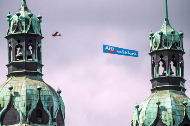 AfD-Banner über dem Marktplatz, ein Flugzeug mit AfD Wahlwerbung kreist am Samstagmittag über der Altstadt, hier über der Marktkirche, Halle (Saale), 29. August 2026 Deutschland, Halle (Saale), 29. August 2026, AfD-Banner über dem Marktplatz, ein Flugzeug mit AfD Wahlwerbung kreist am Samstagmittag über der Altstadt, hier über der Marktkirche, im Bild sind die beiden Hausmannstürme zu sehen, kritische Haltung der evangelischen Kirche zur AfD, an der Marktkirche weiter unten hängt ein Transparent: Mit Menschlichkeit wählen, Landtagswahlen in Sachsen-Anhalt am 6. September, Wahlkampf, Politik,