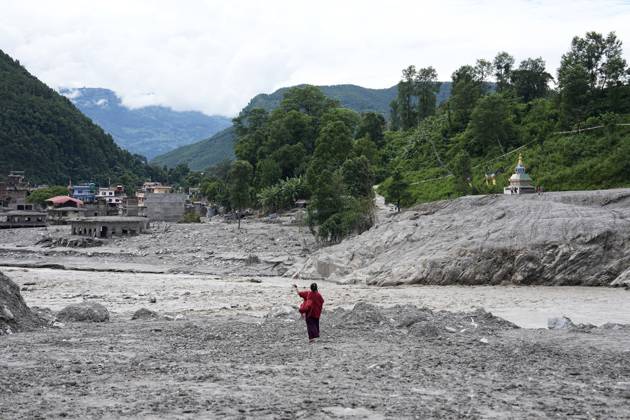 NUWAKOT, NEPAL - SEPTEMBER 01: A woman stands with her arms outstretched by a river on a sandbar north in Nuwakot district on September 1, 2026, seven days after deadly mudslides struck the area. Areas of Nepal are still out of the reach of rescue teams, according to the UN, while the death toll from the disaster now exceeds 1,000.  Copyright: xChinaxNewsxServicex 111663558501