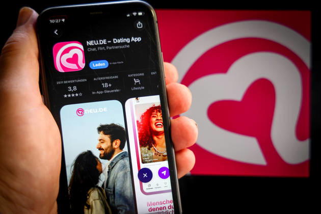 Apple App Store auf einem iPhone. Essenzielle Dating Apps. NEU.DE, Dating app, Chat, Flirt, Partnersuche. Das iPhone wird in der Hand gehalten.. 06.09.2026
