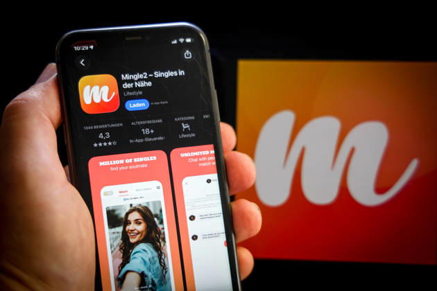 Apple App Store auf einem iPhone. Essenzielle Dating Apps. Mingle2 - Singles in der Nähe. Das iPhone wird in der Hand gehalten.. 06.09.2026