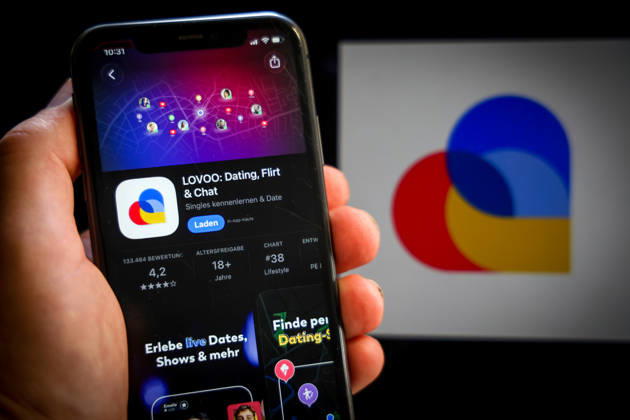 Apple App Store auf einem iPhone. Essenzielle Dating Apps. LOVOO: Dating, Flirt & Chat. Das iPhone wird in der Hand gehalten.. 06.09.2026